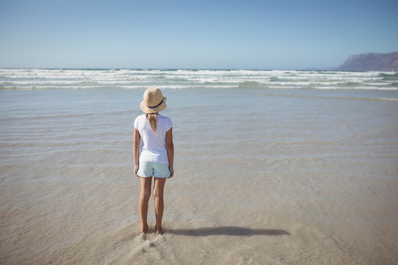 Girl on beach watching the waves